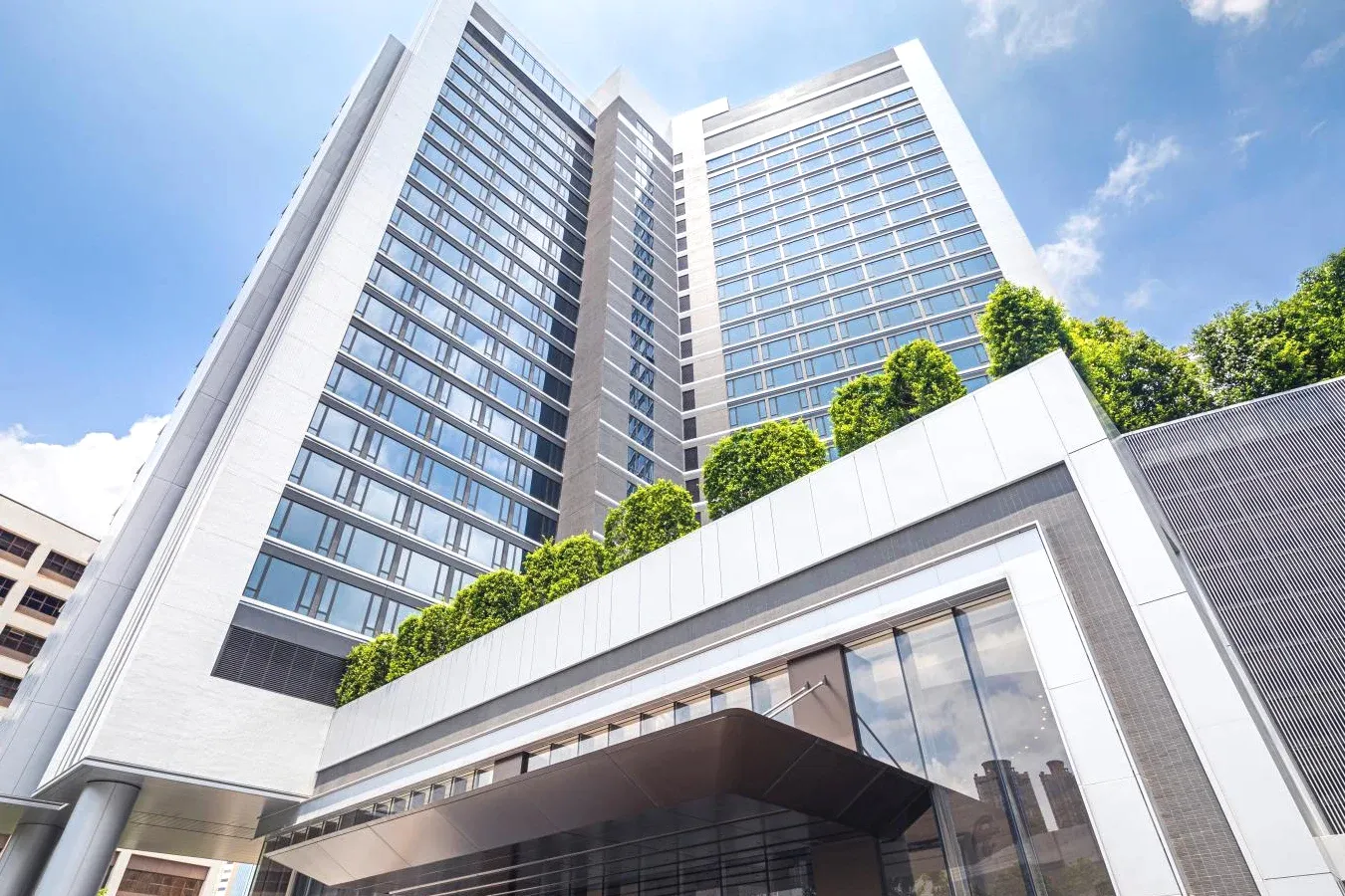 Tall building with trees Elite Luxury Alva Hotel By Royal in Sha Tin District Hong Kong